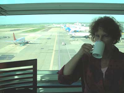 Carol sipping coffee in the President's Lounge at London's Gatwick Airport.